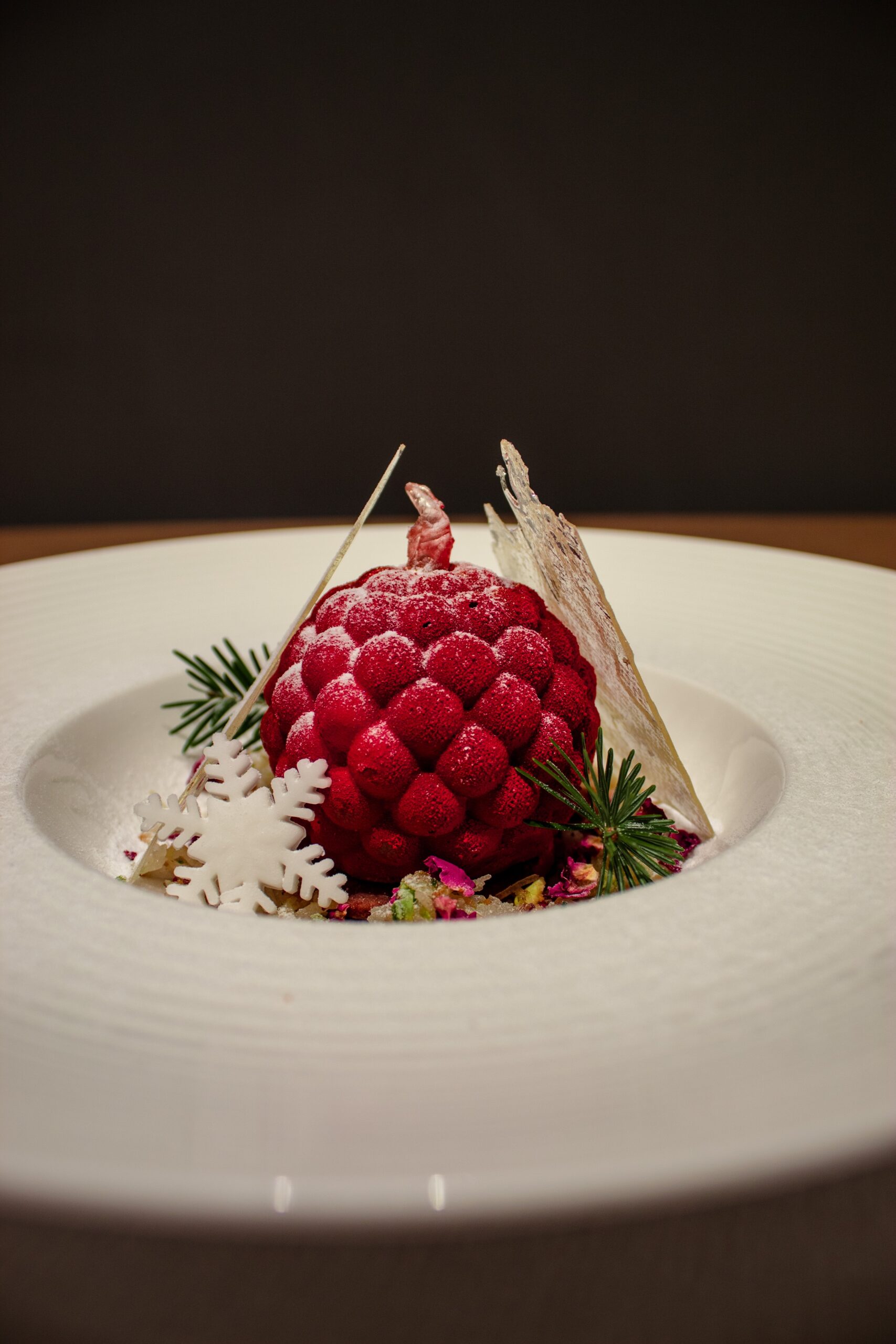 a white plate topped with a dessert covered in raspberries